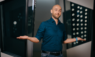 Stian Revheim står ved DNBs myntsamling som er utstilt i Bjørvika. 
